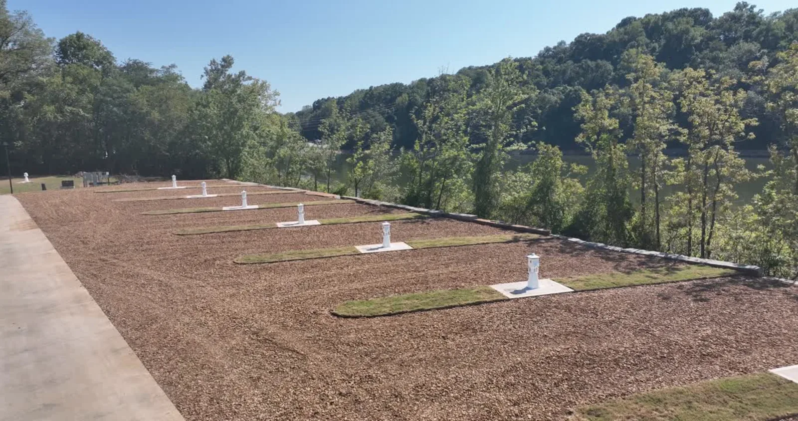 New gravel RV sites with white lighthouse power pedestals