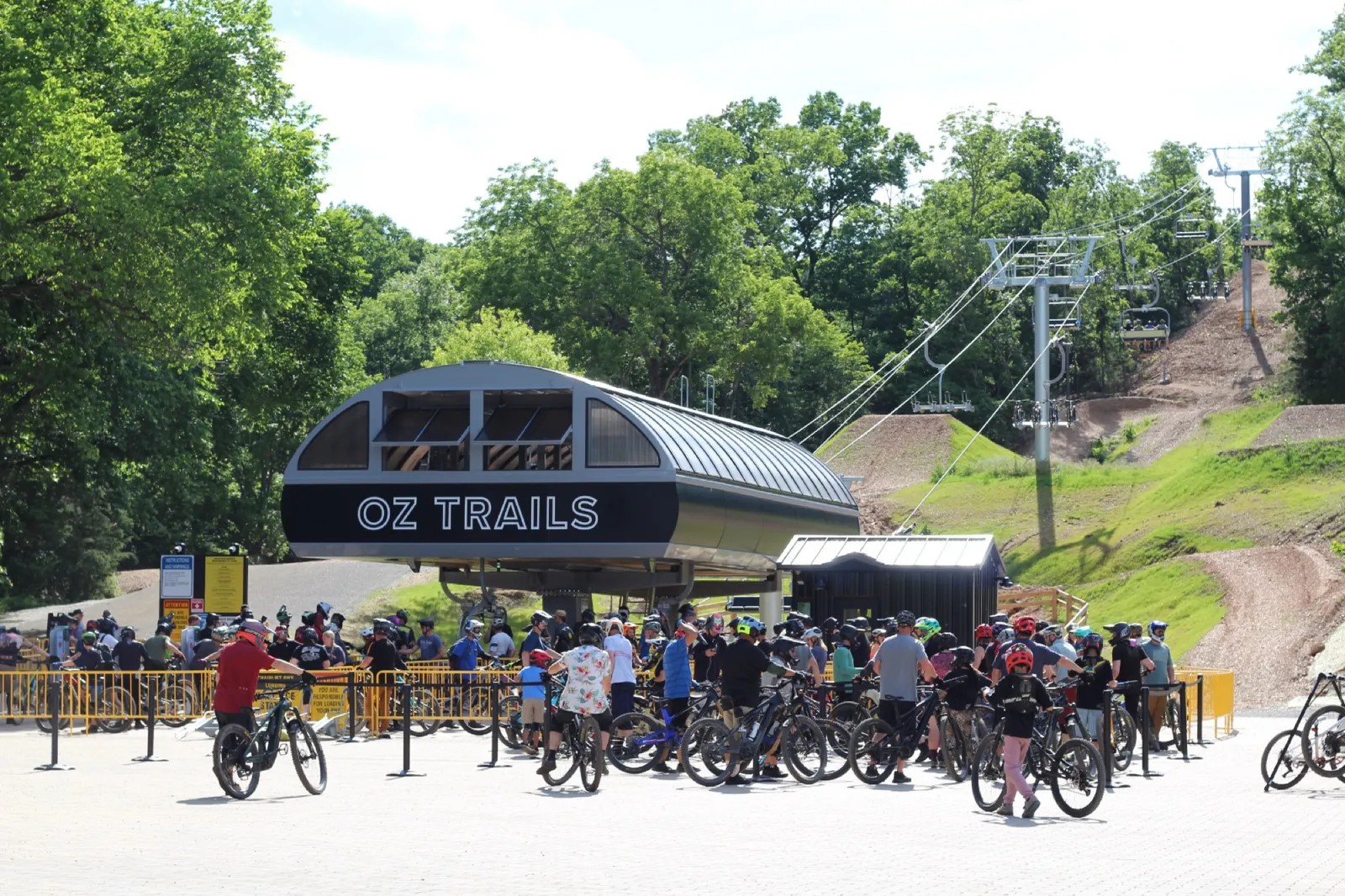 Riders gathering beneath the high-speed quad at OZ Trails Bike Park